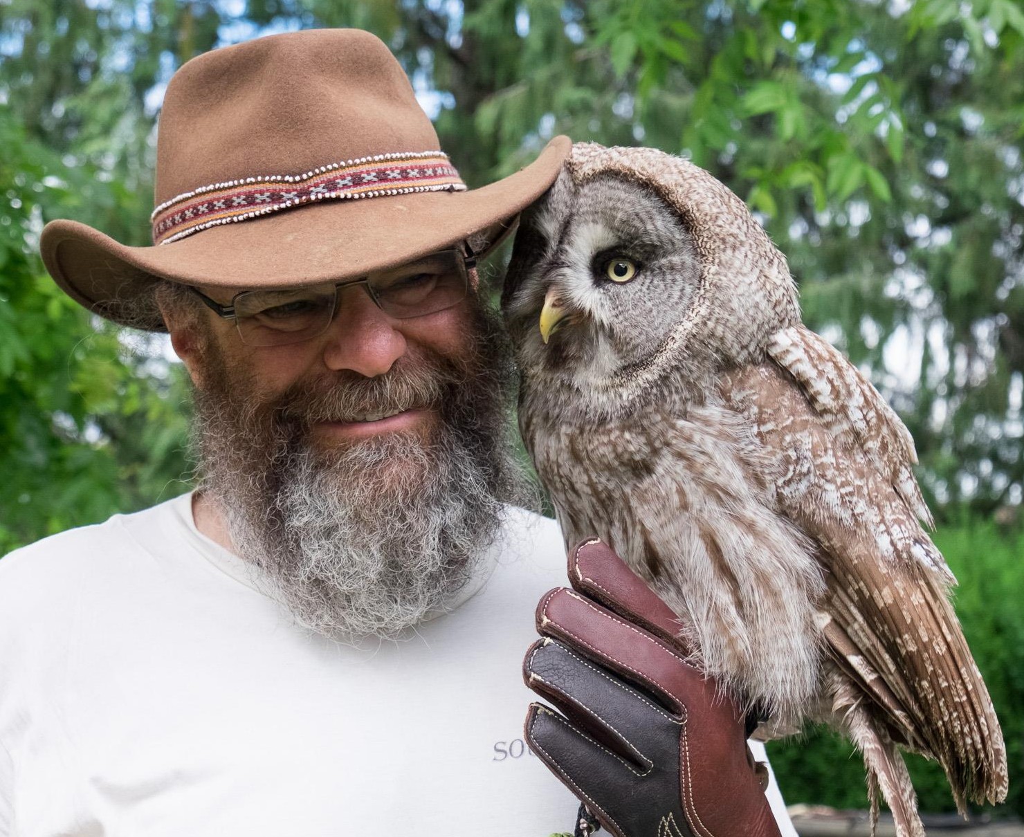 Richard Grossman, founder of SoundJourney.com, standing beside an owl